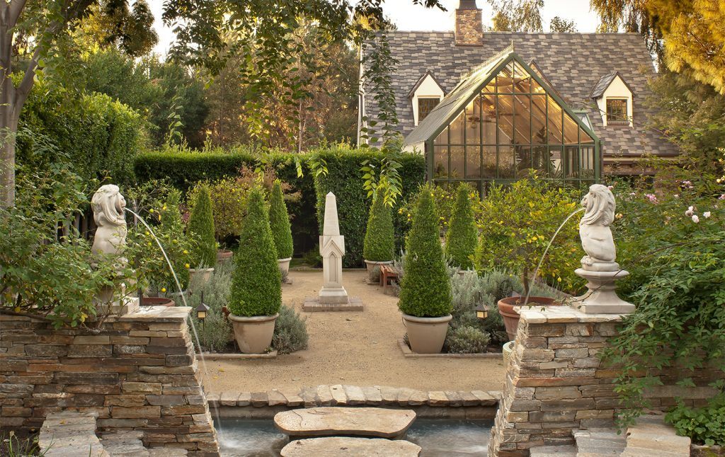 English tudor style garden with fountains and greenhouse.