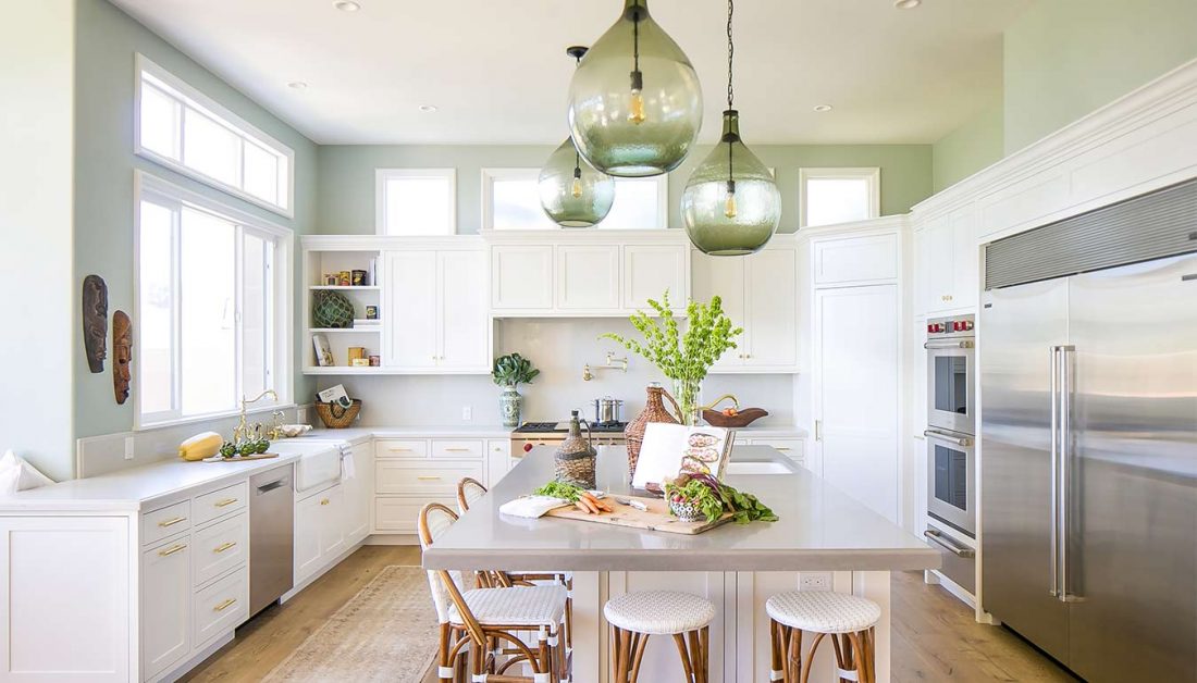 SugarPine remodel showcase featuring stainless steel appliances, white cabinets, and brass cabinet fixtures.