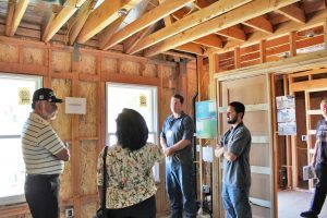 HartmanBaldwin staff presenting new project inside with exposed framing.
