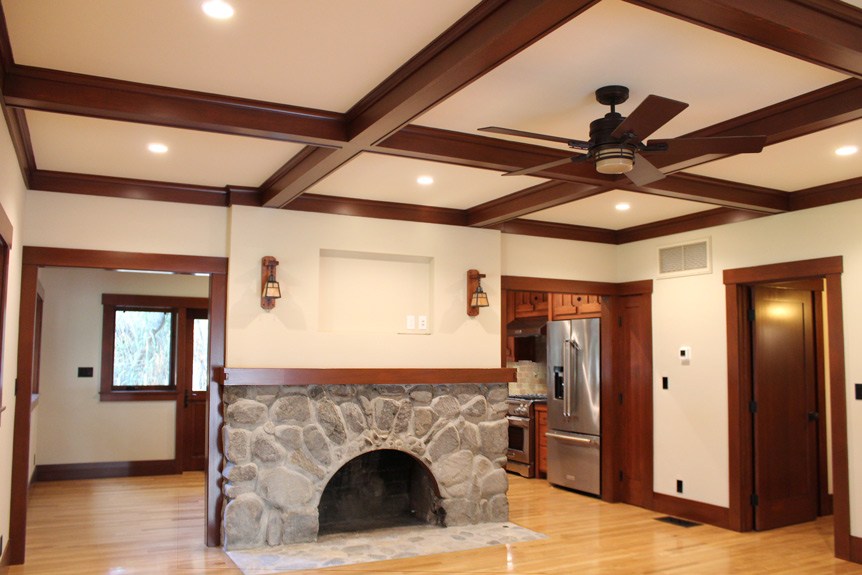 After image of Canyon residence's fireplace and new living space. Exposed beams and wood floors.