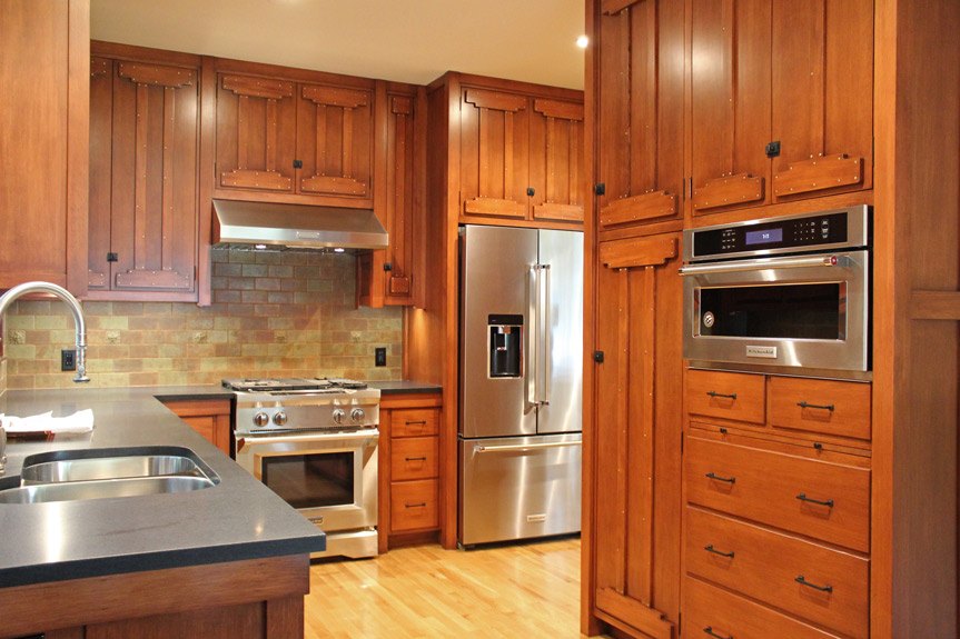 After image of Canyon residence project's kitchen. Wood cabinetry, stainless steel appliances, wood floor.