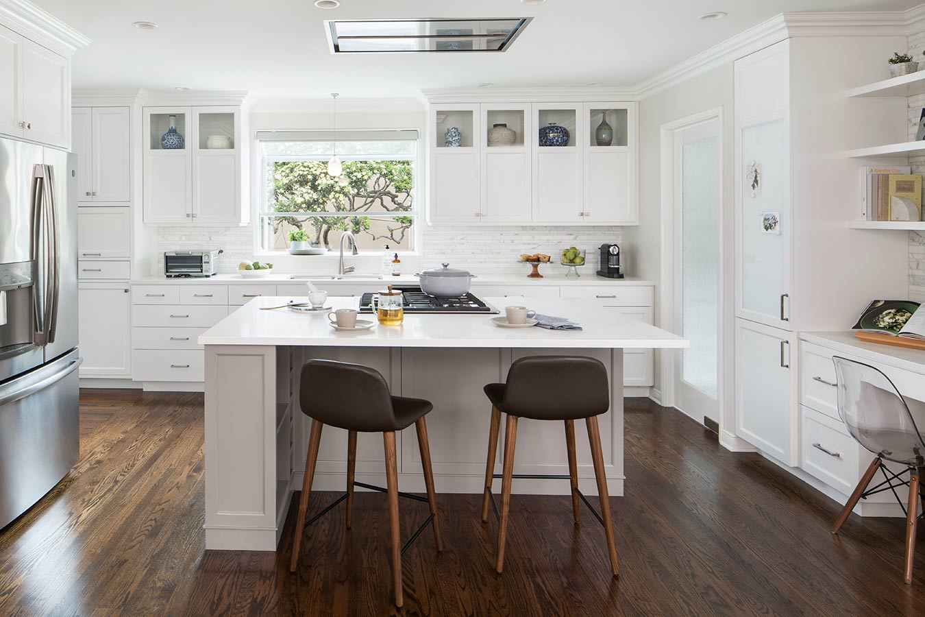 Sleek and contemporary kitchen remodel with white cabinetry and countertops.