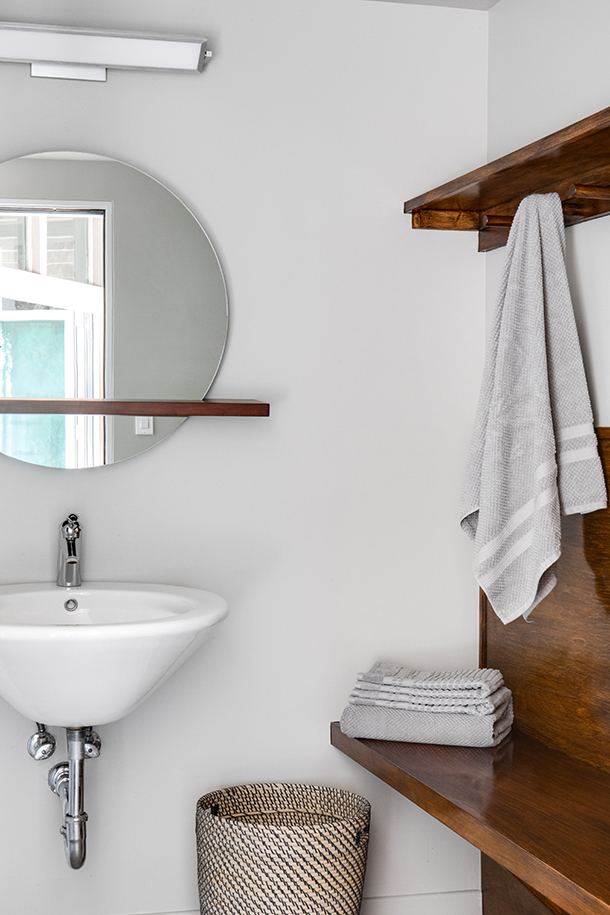 HartmanBaldwin Robin Residence Mid Century Modern Pool Bathroom Mid Century Modern pool bathroom remodel with dark stained wood towel hanger and circular mirror with wood accent