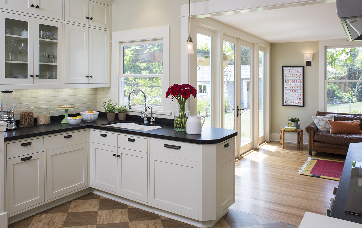 HartmanBaldwin Fair Park Residence Kitchen and Living Room - Hartman Baldwin Pre-Launch Remodeled kitchen with off-white cabinetry, white subway tile backsplash, black countertops and hardware, and and living room with French doors seen beyond