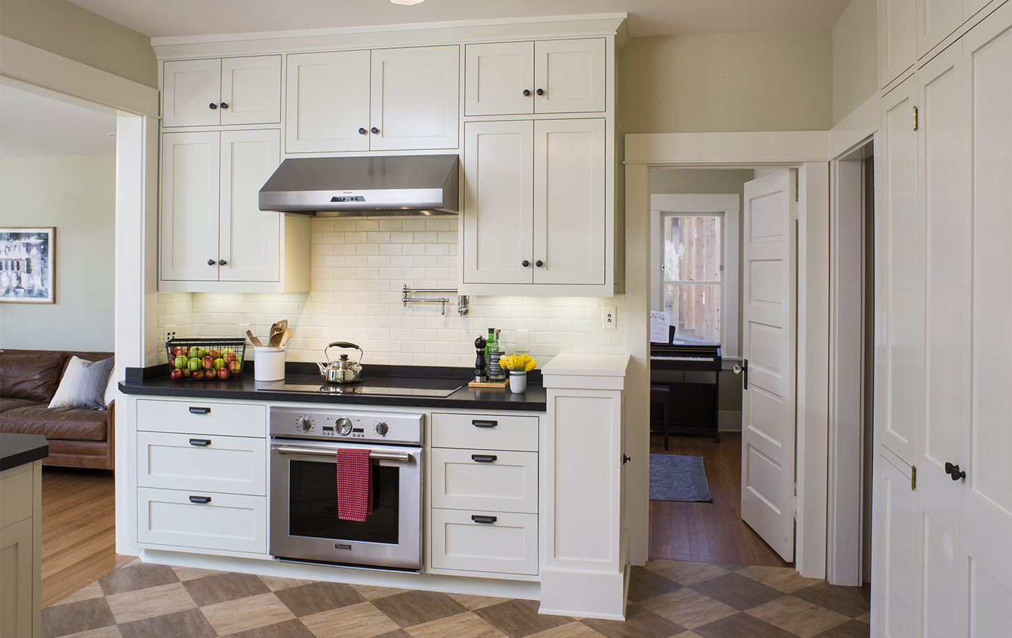 HartmanBaldwin Fair Park Residence Kitchen Stove - Hartman Baldwin Pre-Launch Remodeled kitchen with off-white cabinetry, white subway tile backsplash, black countertops and hardware, and sleek oven, stove, and vent.