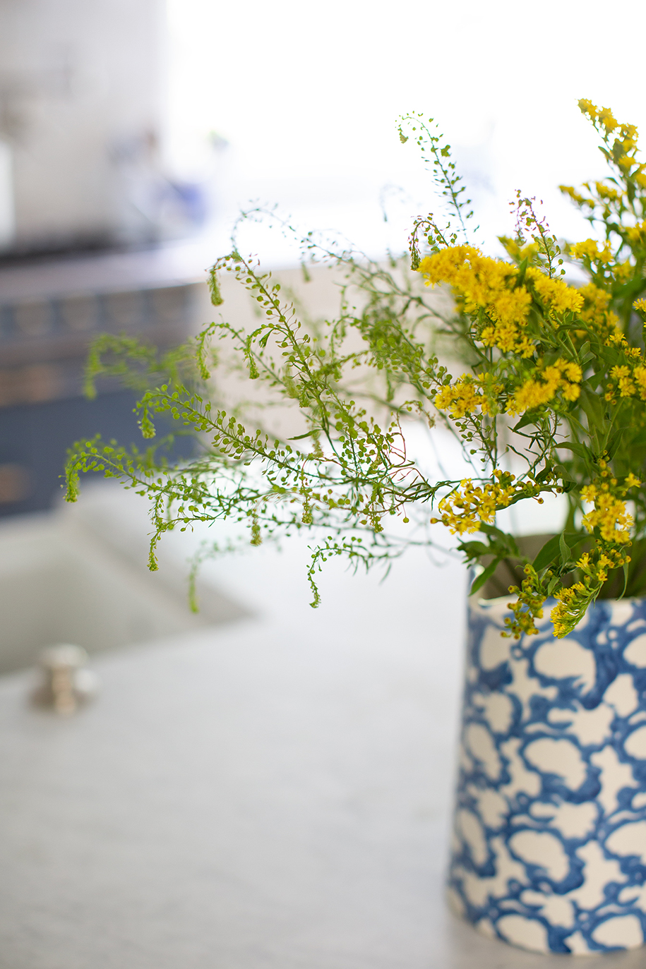 Yellow floral arrangement in blue ceramic vase