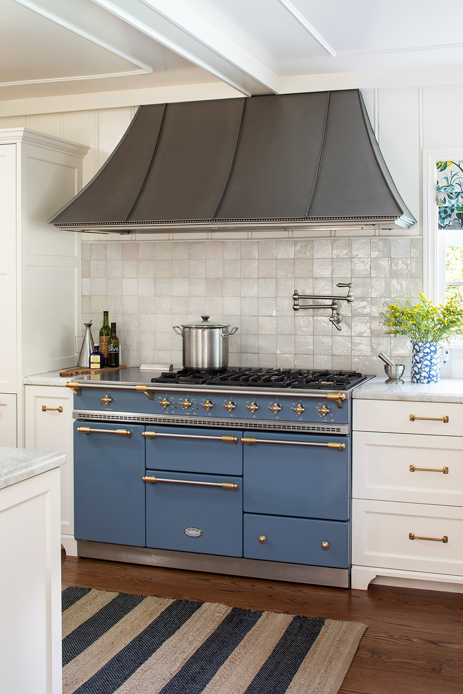 Cape Cod coastal-inspired kitchen remodel with Blue French Lacanche range, textured zellige backsplash tile, and aged brass hardware