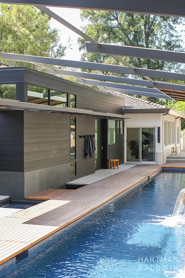Modern California home remodel new backyard with teak paneled patio, hot and cold plunge pools, and luxury lap pool with waterfall and retractable steel shade structure