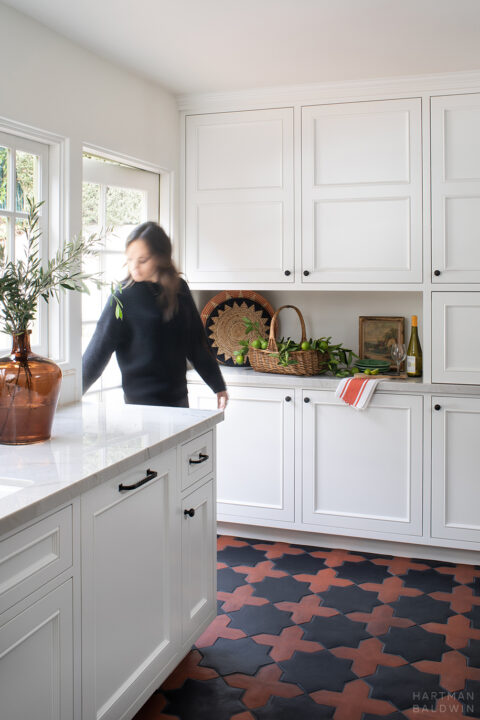 Woman walking through door from outside into remodeled Spanish style kitchen
