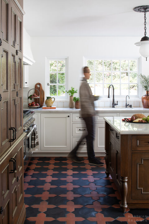 Spanish-style kitchen remodel with dark-stained Andalusian-inspired cabinetry and patterned terracotta tile flooring