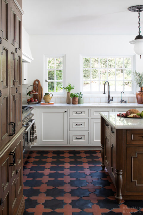 Spanish-style kitchen remodel with dark-stained Andalusian-inspired cabinetry and patterned terracotta tile flooring