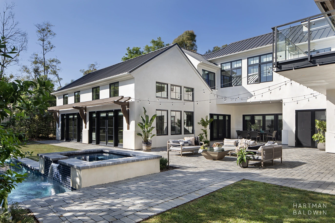 New custom LA modern farmhouse-style home and backyard with pool, spa, string lights, and outdoor furniture