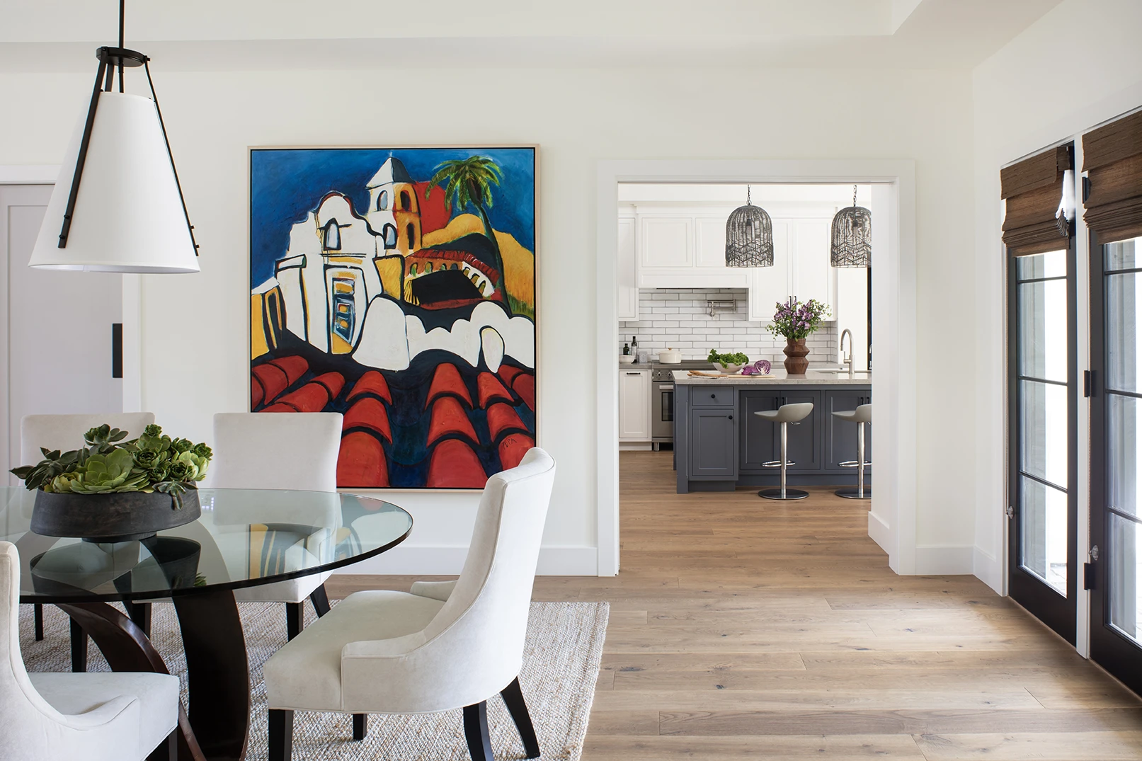 HartmanBaldwin Barrington Residence New Custom Modern Farmhouse Dining Room and Kitchen COVER - Hartman Baldwin Pre-Launch New custom modern dining room with a large colorful painting on the wall and the kitchen with white and blue cabinetry seen beyond