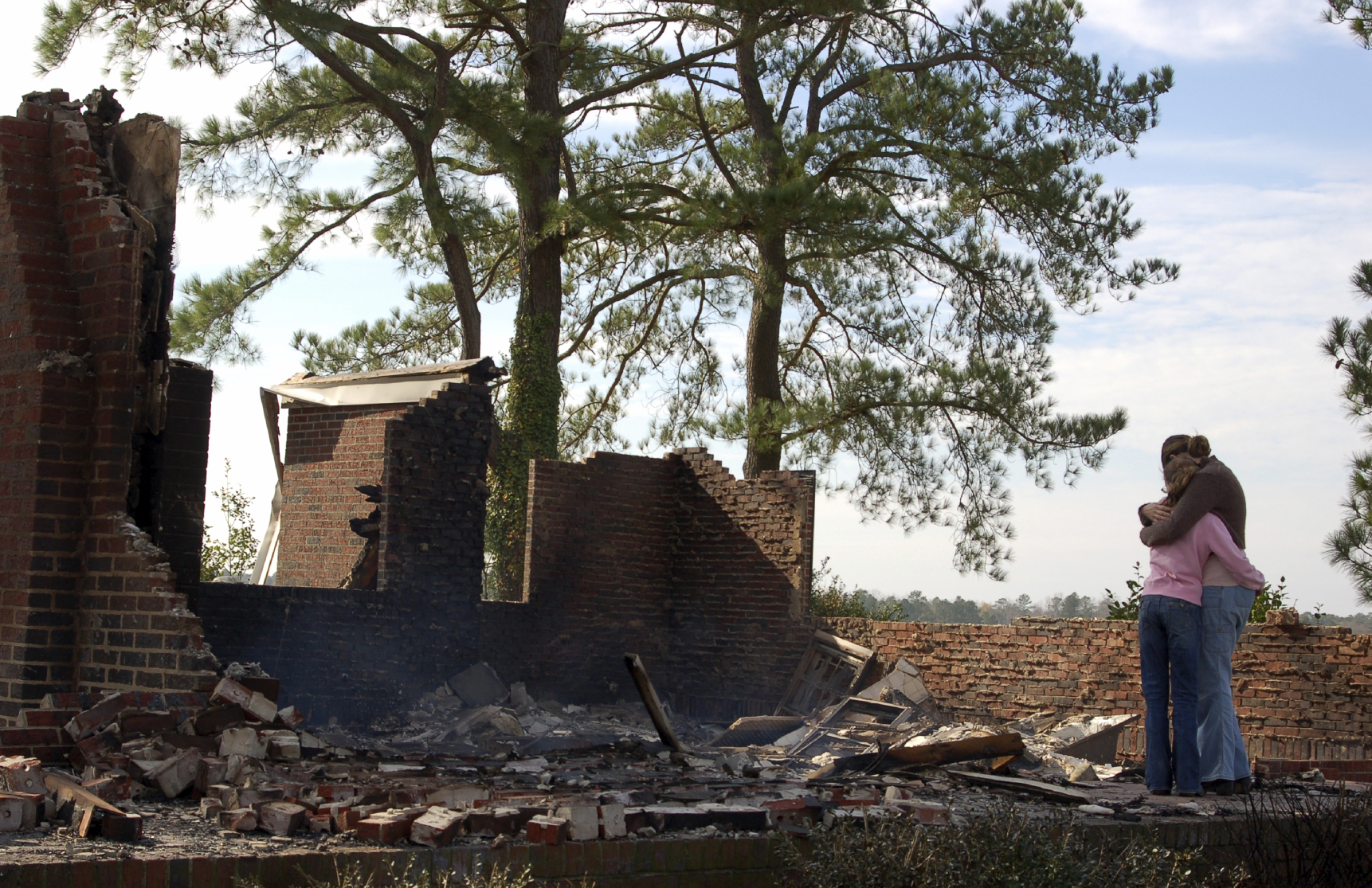 iStock Home Loss to Fire - Hartman Baldwin Pre-Launch Couple hugging in front of burned-down home