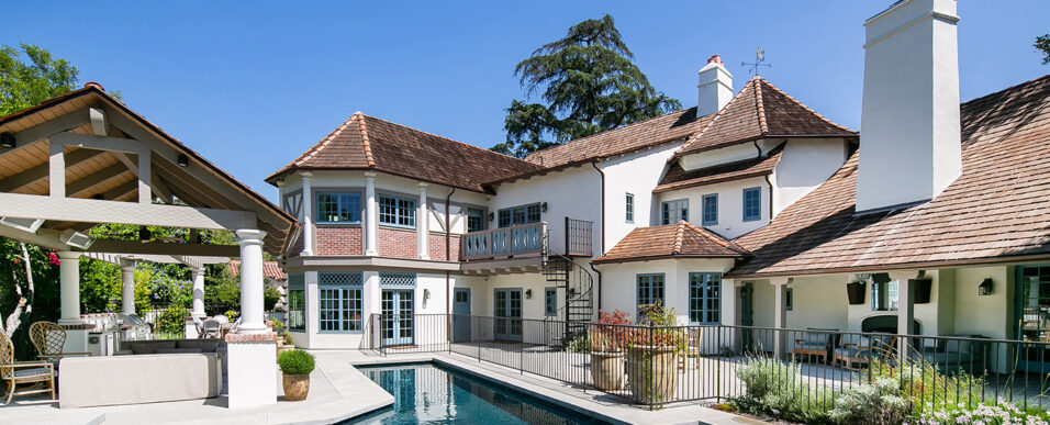 Remodeled French Normandy-style home back exterior, pool, and outdoor living space