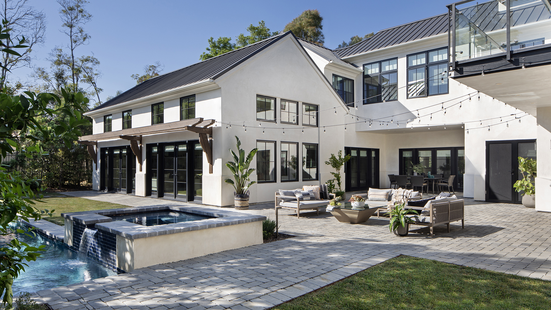 New custom LA modern farmhouse-style home and backyard with pool, spa, string lights, and outdoor furniture